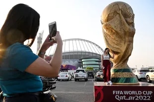 A woman poses in front of the Khalifa Stadium in Doha, in advance of the World Cup