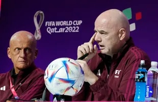 FIFA President Gianni Infantino (right) talks to journalists with referee committee director Pierluigi Collina (left) in Doha, Qatar, Friday, Nov. 18, 2022. (AP Photo/Martin Meissner)